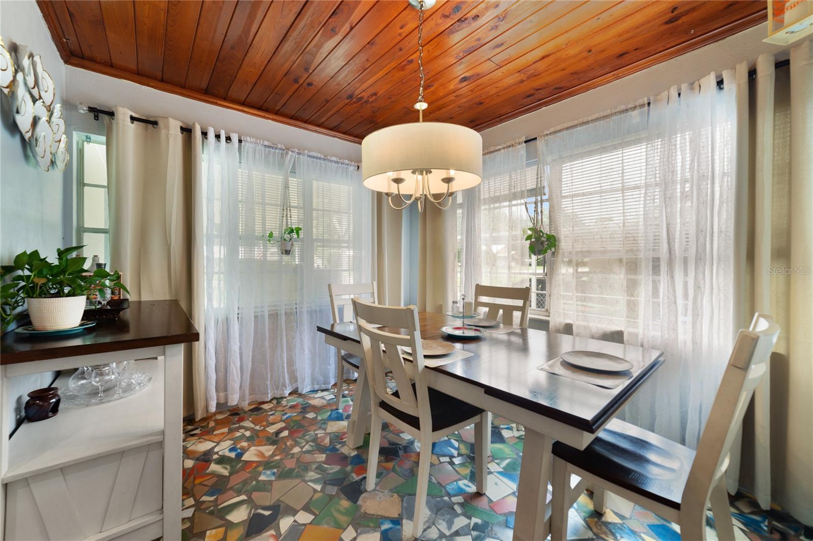 A flexible dining space with a wood slat ceiling and large windows makes it easy to entertain or customize for whatever you need!