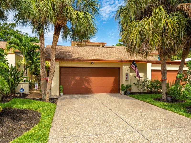 Landscaped, tropical front framed with palm trees!