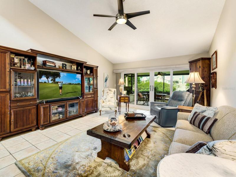 Great room with new verticals and terrific new triple pane sliding glass doors with access to Florida-patio room with private greenbelt beyond.