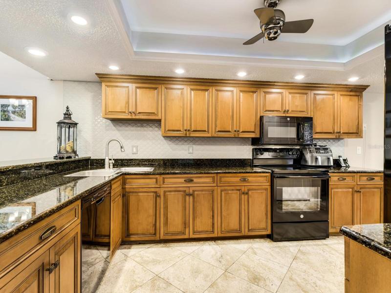 Beautifully upgraded with wood cabinets, granite counters and stylish tiled backsplash