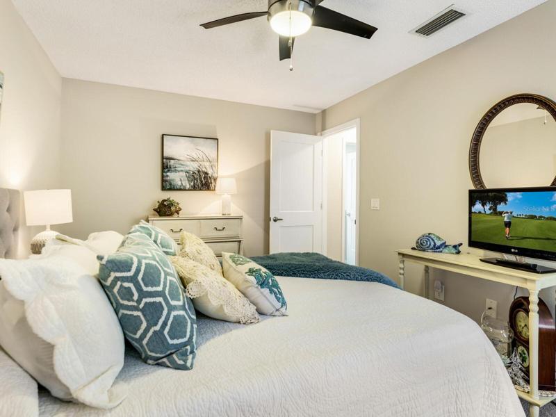 Guest suite painted in soft, neutral tone with contemporary fan & light & new entry door.