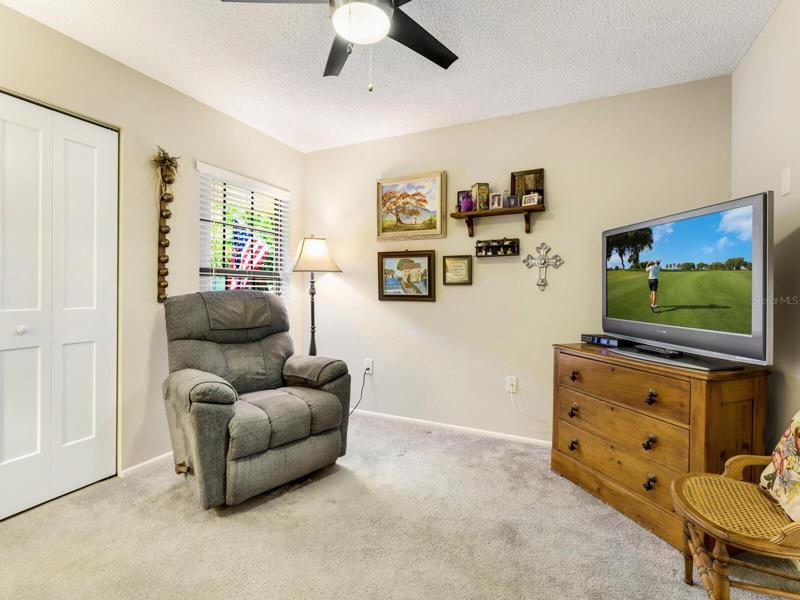 Third bedroom or den with ceiling fan/light.  Sizable closet can fit a desk for home office.