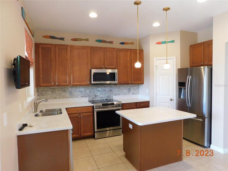 Sizable kitchen loaded with fine, upscale backsplash, solid surface countertops, newer appliances, and more!