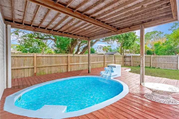 VIRTUALLY STAGED photo showing water-filled pool with waterfall