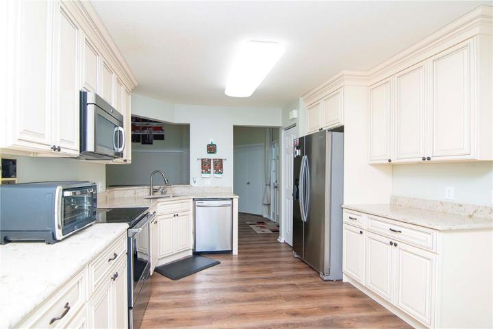 Kitchen with Quartz countertops, wood cabinets, and stainless steel appliances