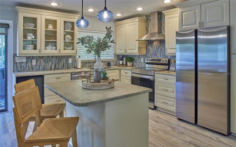 Spacious island kitchen with wine refrigerator, brand new Samsung range, refrigerator and dishwasher.