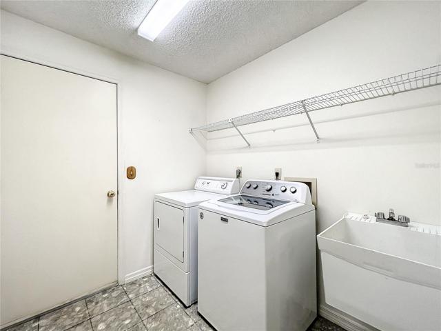 Inside laundry room with utility sink and shelving