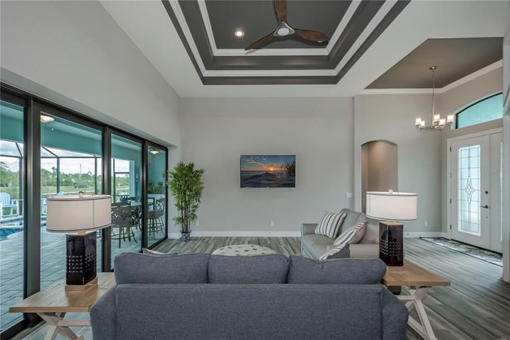 living room with coffered ceilings and zero degree sliders