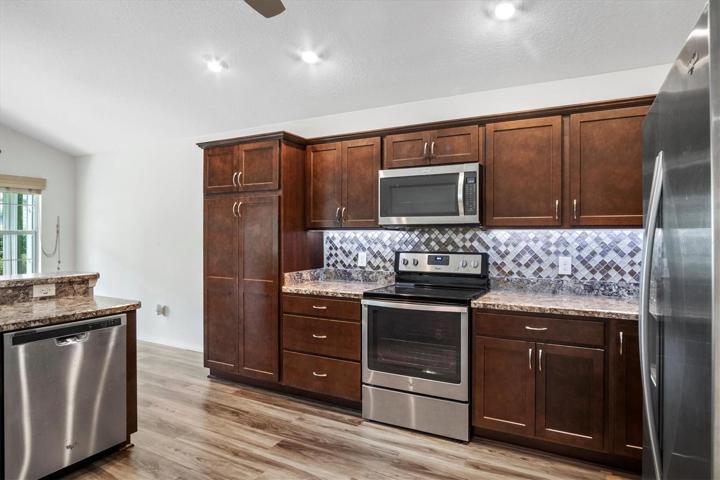 STAINLESS STEEL APPLIANCES AND DARK MAPLE CABINETRY