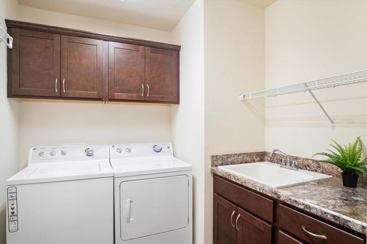 GREAT LAUNDRY ROOM WITH ROOM TO HANG CLOTHES AND CABINETS.