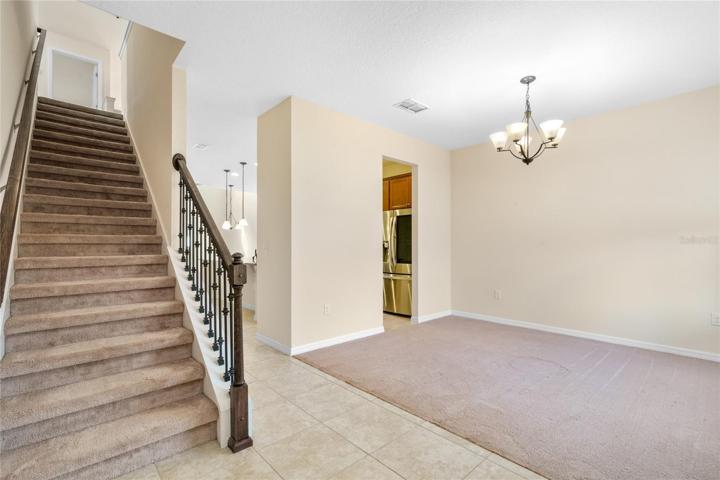 Foyer entrance into Dining Room, Kitchen and Great Room, highlighted by wrought iron stairway.