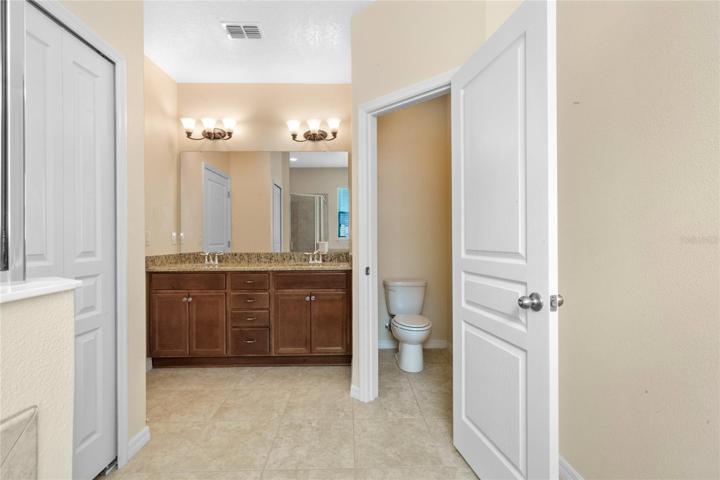 Master ensuite Bath showing dual vanity with drawers, linen closet and seperate toilet room.