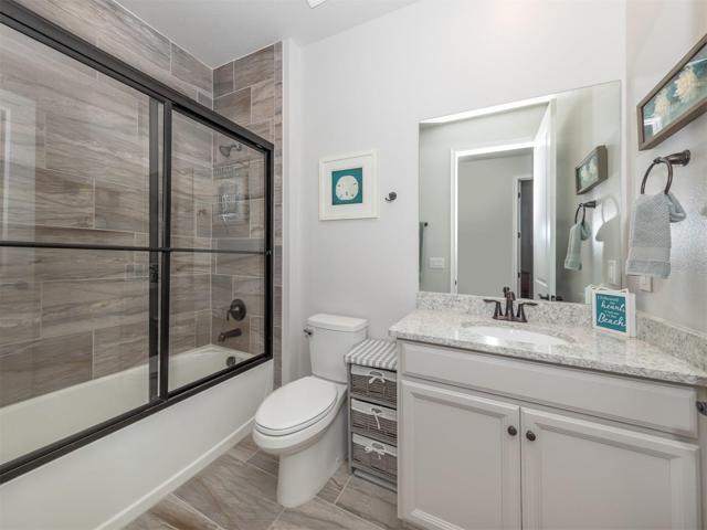 The additional bathroom offers solid wood cabinetry quartz countertops and glass shower doors