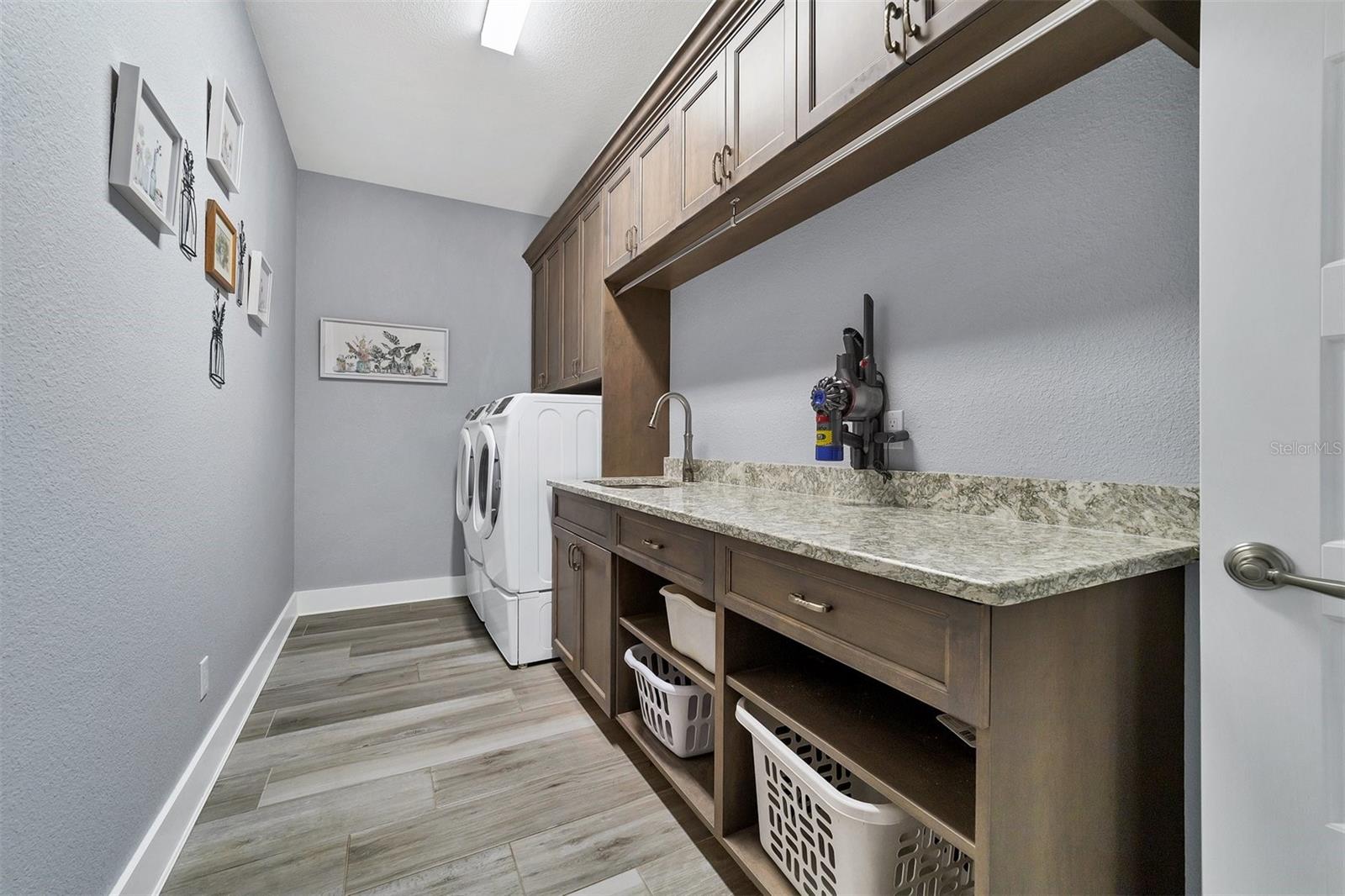 Large laundry room with extended counter and cabinetry.