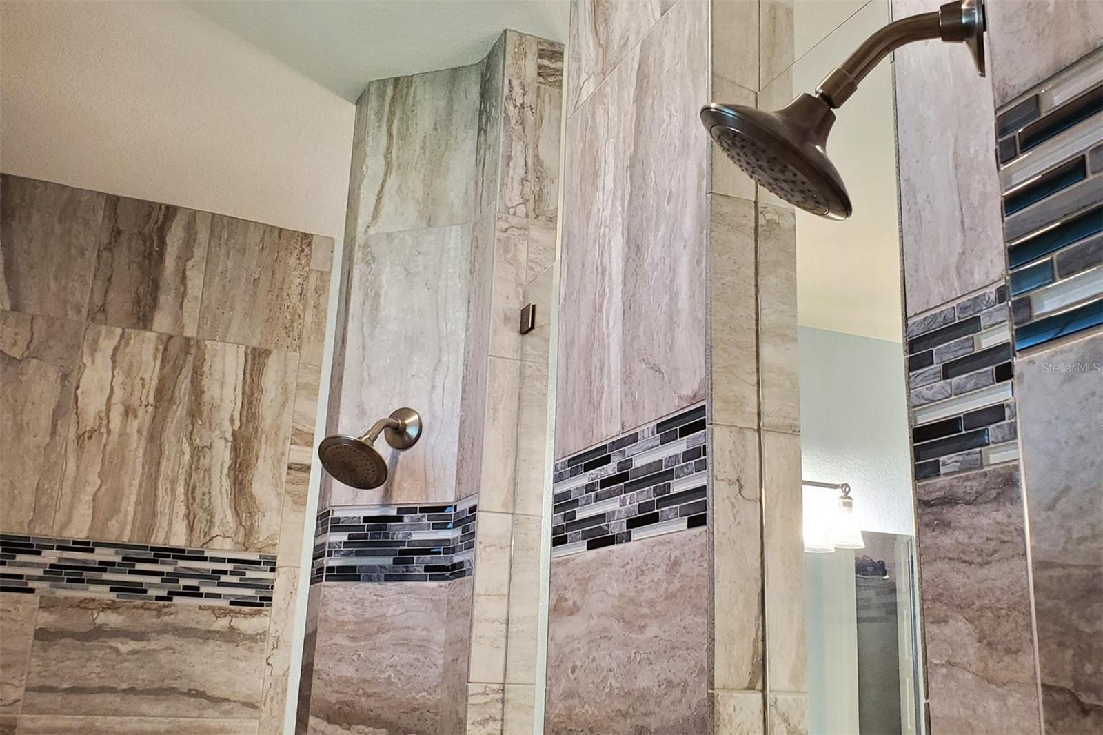 Two shower heads with separate controls.
