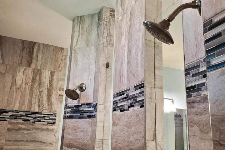 Two shower heads with separate controls.