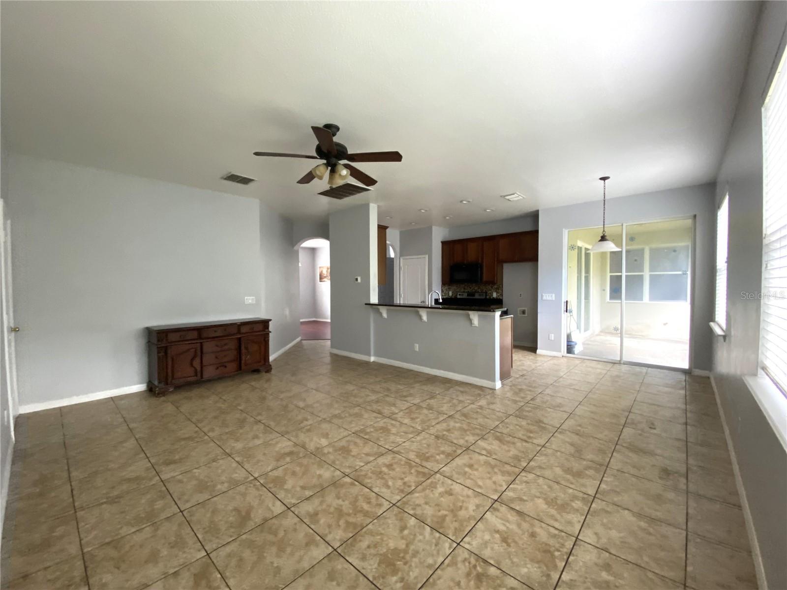 Family room looking towards bar, kitchen and dinette on right.  Slider entrance to lanai and fenced back yard.