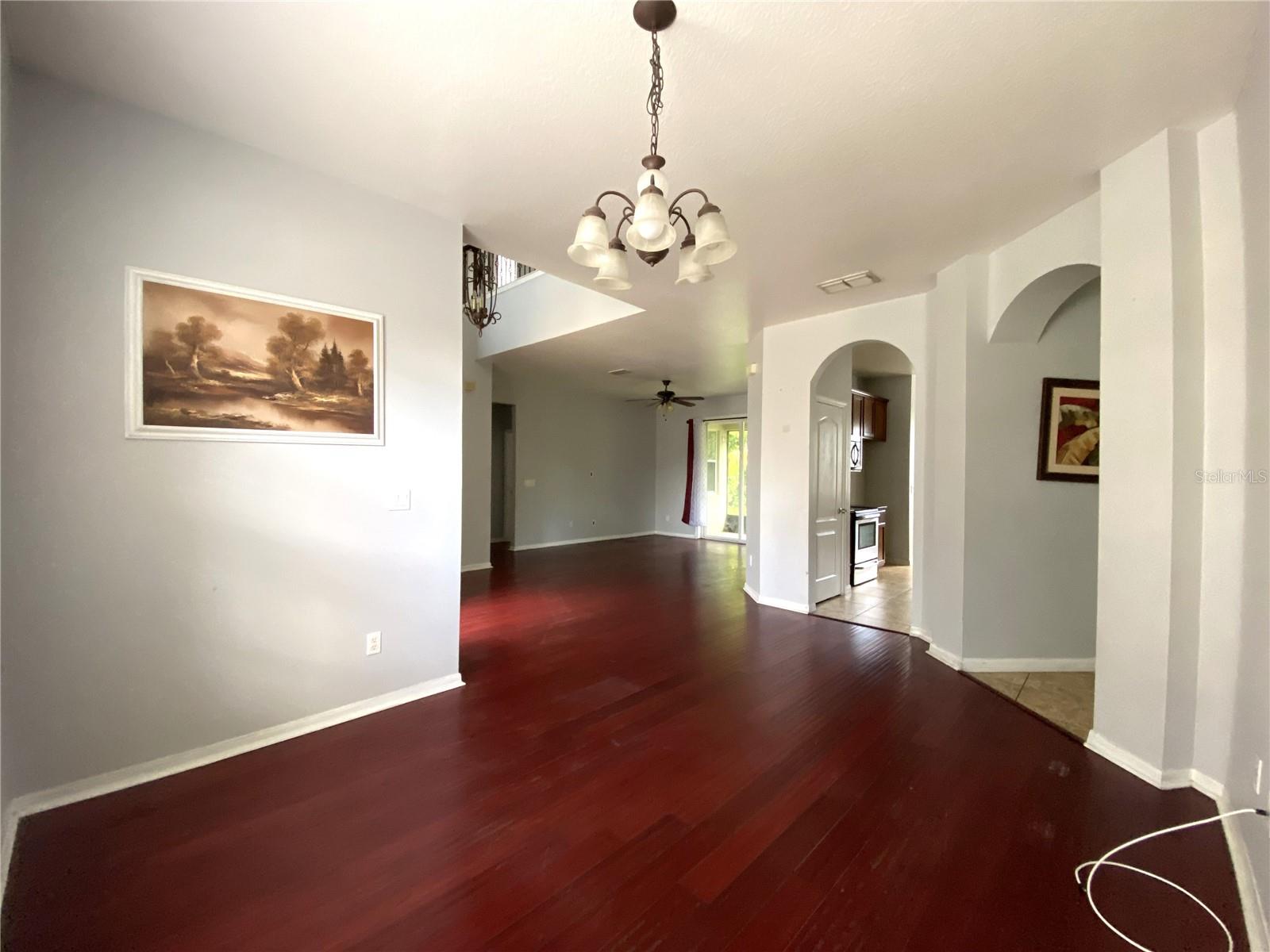 View from dining room into living room with kitchen and family room entrances on right