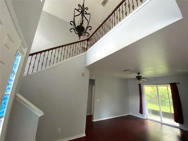 Another view of living room from dining room with front door and stairs entrance on left and a peek into the hall that leads to master bedroom in the middle