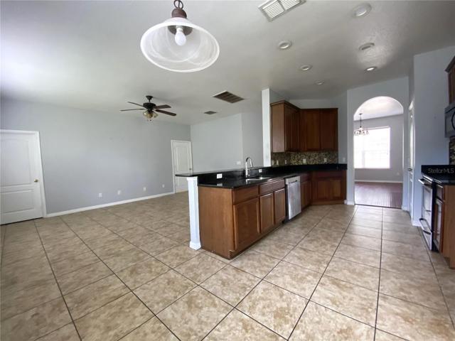 View from dinette area by slider into kitchen, bar and family room.  Door leads to laundry room and garage.