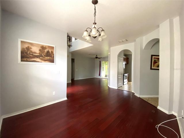 View from dining room into living room with kitchen and family room entrances on right