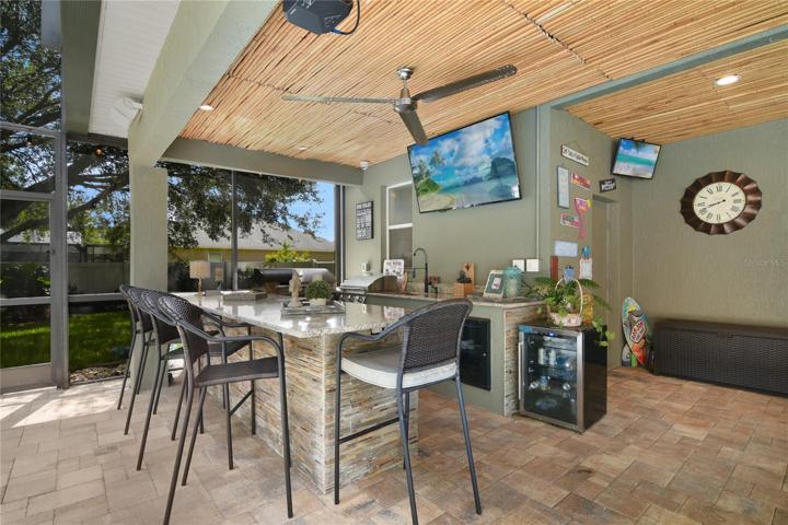 Covered lanai features a custom outdoor kitchen and bar!