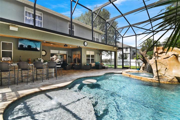 The exterior of the home is just as stunning as the interior where your SCREENED POOL boasts fiber optic lighting, water slide, sun shelf, built-in table and a SPA with a rock grotto and waterfall!