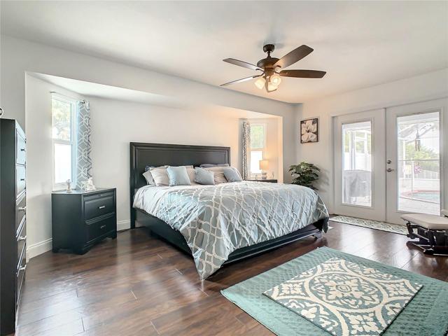 Master Bedroom. Spacious and large enough for a Kingsize bed and features French Doors to the Lanai/Pool and are Hurricane Impact with Enclosed Shutters. Flooring is LVP (Luxury Vinyl)