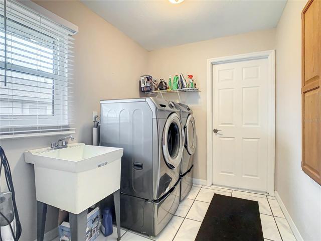 Inside Laundry with Utility Tub and Closet Storage. Washer and Dryer stay and were new in 2022