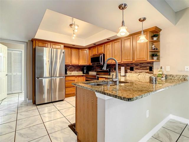 Updated Kitchen with all New in 2022 Samsung Stainless Stell Appliances, Wood Cabinets, Granite Countertops, Tile Back Splash, Double Stainless-Steel Sink with Hands Free Faucet and Tray Ceiling and Breakfast Bar.