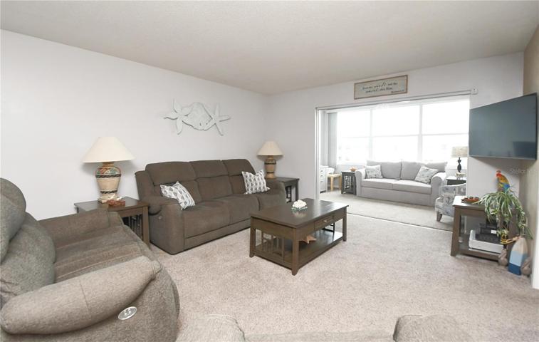 One of the highlights of this condo is the bonus Florida room, bathed in natural light and featuring sliding glass doors.