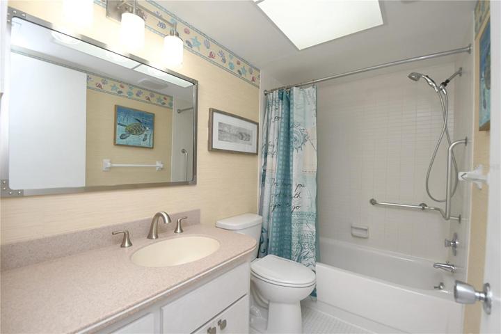 2nd bathroom comes with a bathtub, vanity with a make up area, mirror and overhead lighting.