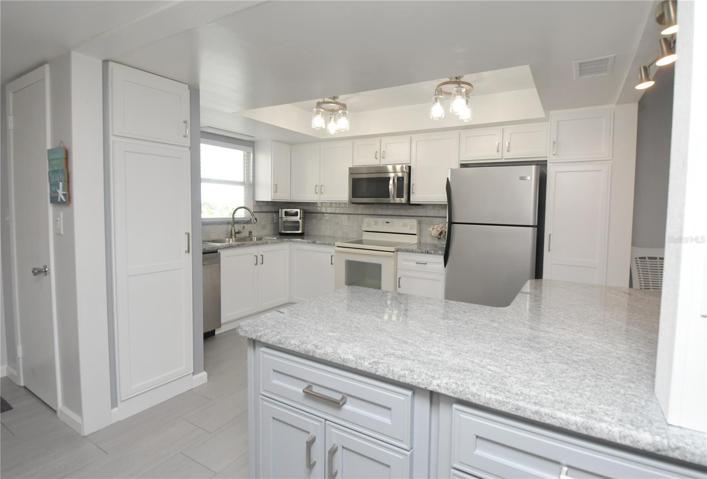 Kitchen features a tray ceiling with 2 beautiful light fixtures.