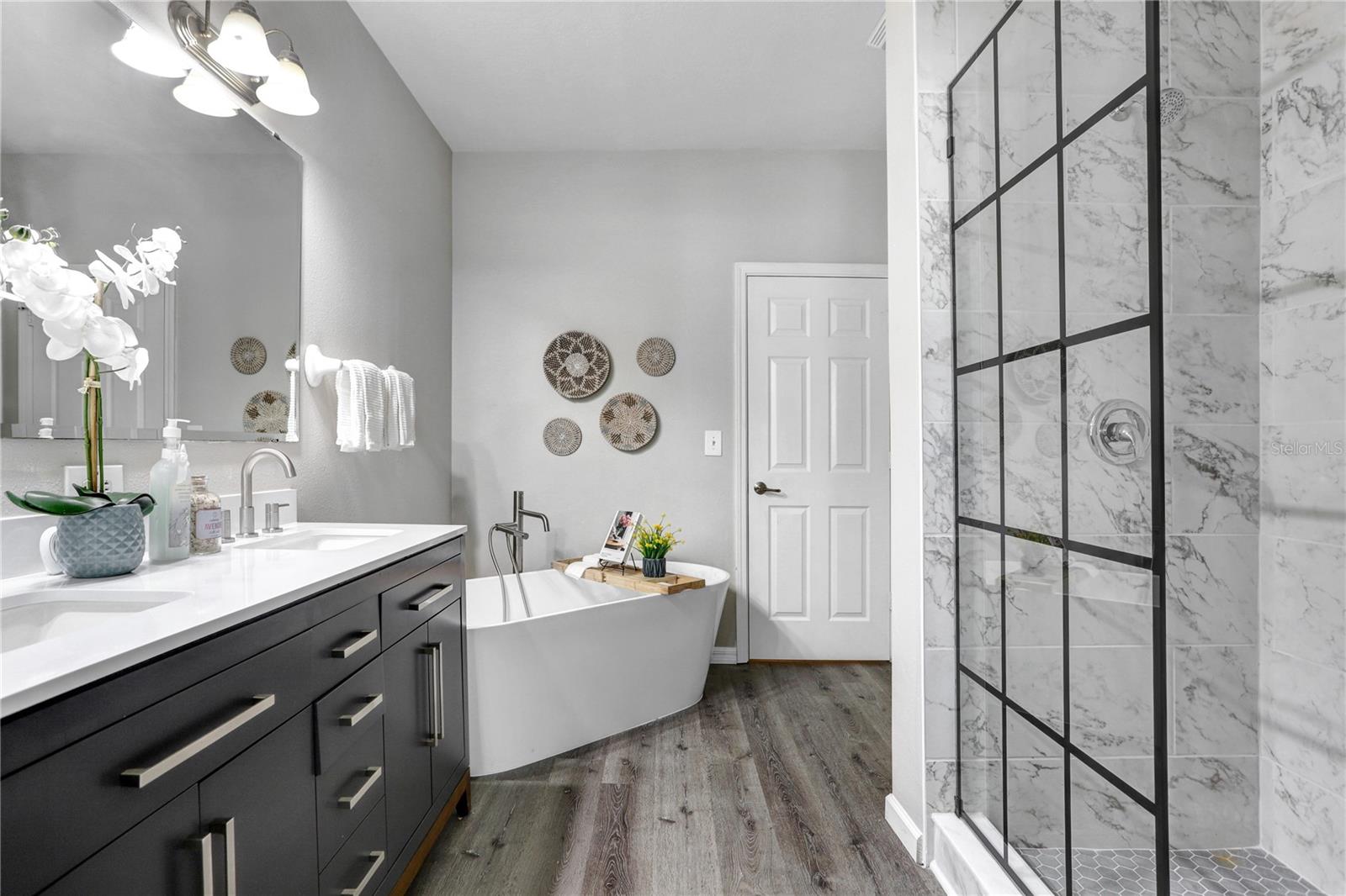 The master bathroom has a beautiful walk-in shower, a free-standing tub, and a big walk-in closet!