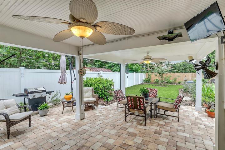 Large back porch with brick pavers and bead board ceiling