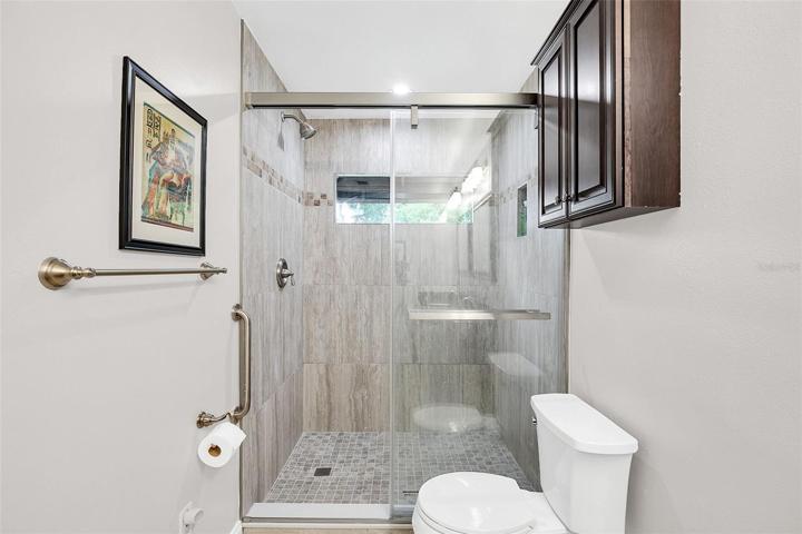 Owners bath with renovated, modernized shower with upper window