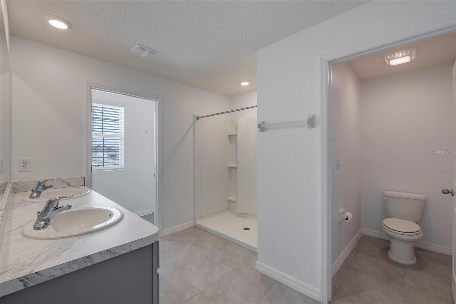 Primary bath with dual vanities and dual closets