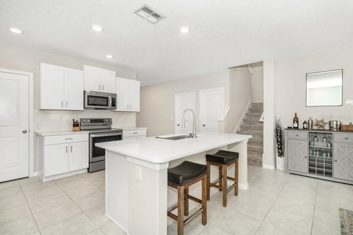The kitchen has been updated with QUARTZ countertops with matching backsplash, large and deep stainless steel drop-in sink with commercial faucet, luxury stainless steel LG appliances, and LED cabinet lighting.
