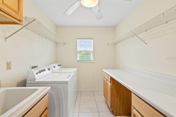 Spacious laundry area featuring abundant cabinet and countertop room.