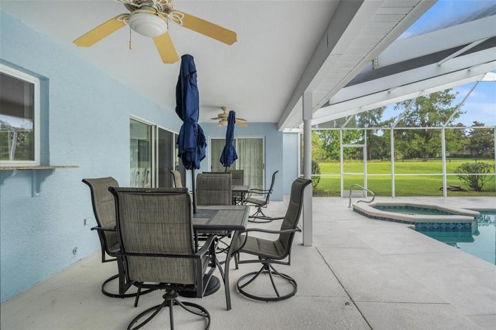 A stunning pool featuring a luxurious jacuzzi and ample space to unwind and savor the outdoors amidst the beauty of nature.