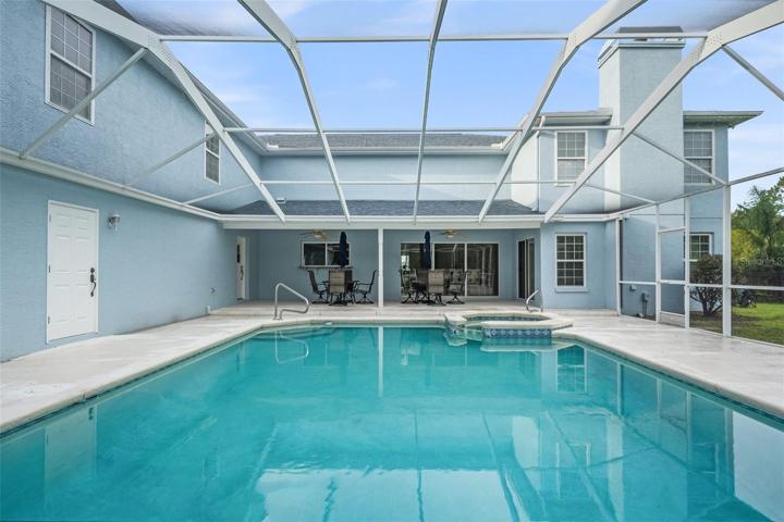 A stunning pool featuring a luxurious jacuzzi and ample space to unwind and savor the outdoors amidst the beauty of nature.