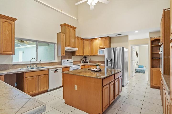 The kitchen area is designed with an open concept, allowing for a seamless view of the pool area through large sliding glass doors.