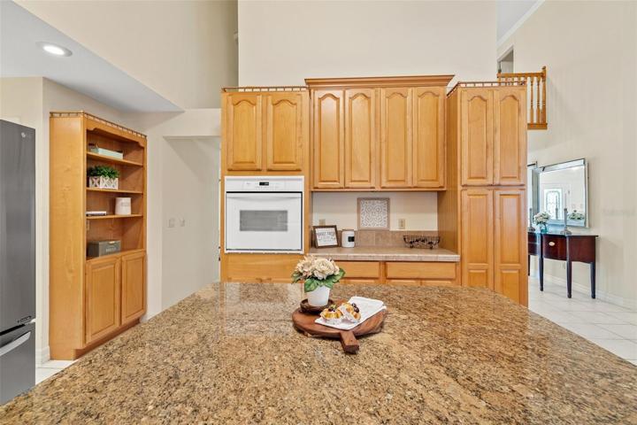 The kitchen area is designed with an open concept, allowing for a seamless view of the pool area through large sliding glass doors.