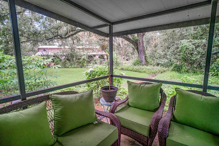 Primary residence screened porch with view to the barn