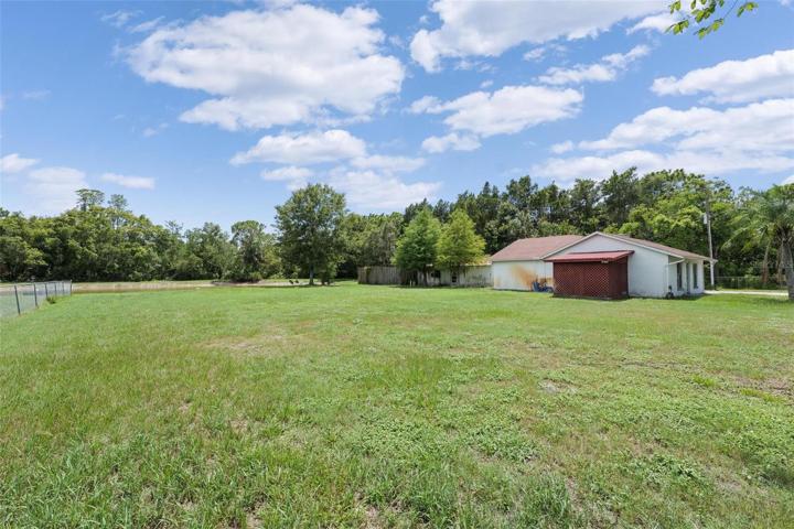 Large backyard overlooking pond and detached garage.