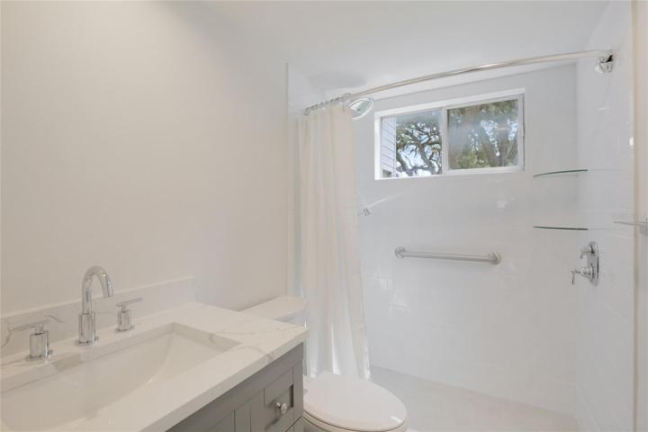 The bathroom is an oasis of white subway tile and a chic gray vanity with a beautiful quartz countertop.