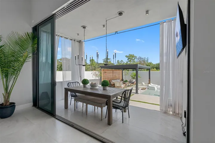 Dining Al fresco. Bring the outdoors in with triple stacked sliding to covered lanai and pool.