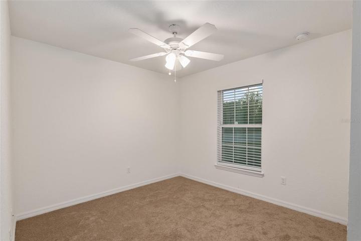 Bedroom 2 with ceiling fan and carpet
