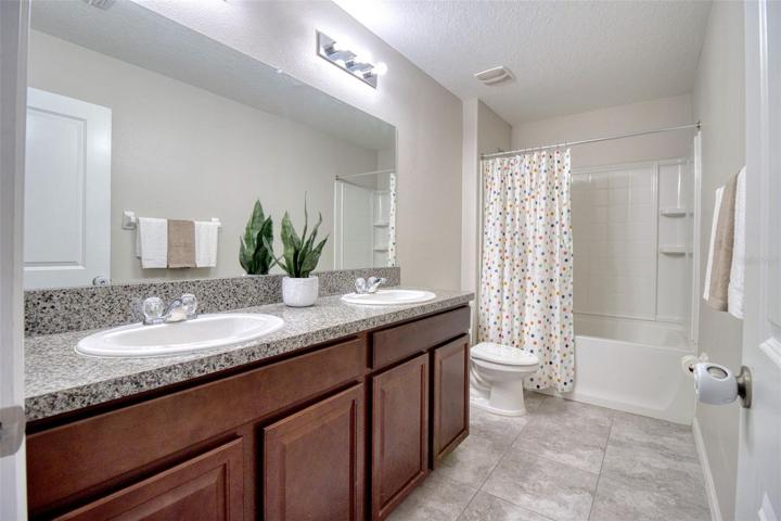 Bathroom 3 has another bathtub and an extra long vanity with double sinks.