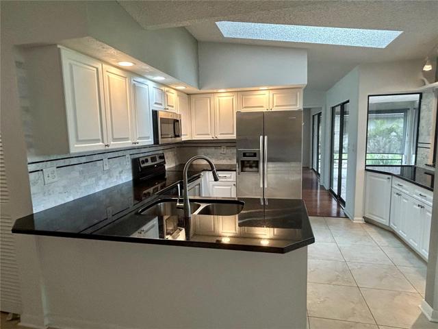 The kitchen is complete with granite countertops and tiled backsplash.